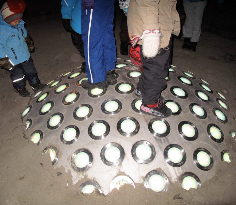 Flera personer står på en stålkupol med vita lampor som sticker upp ur snön. Markus Lantto, Termonoder