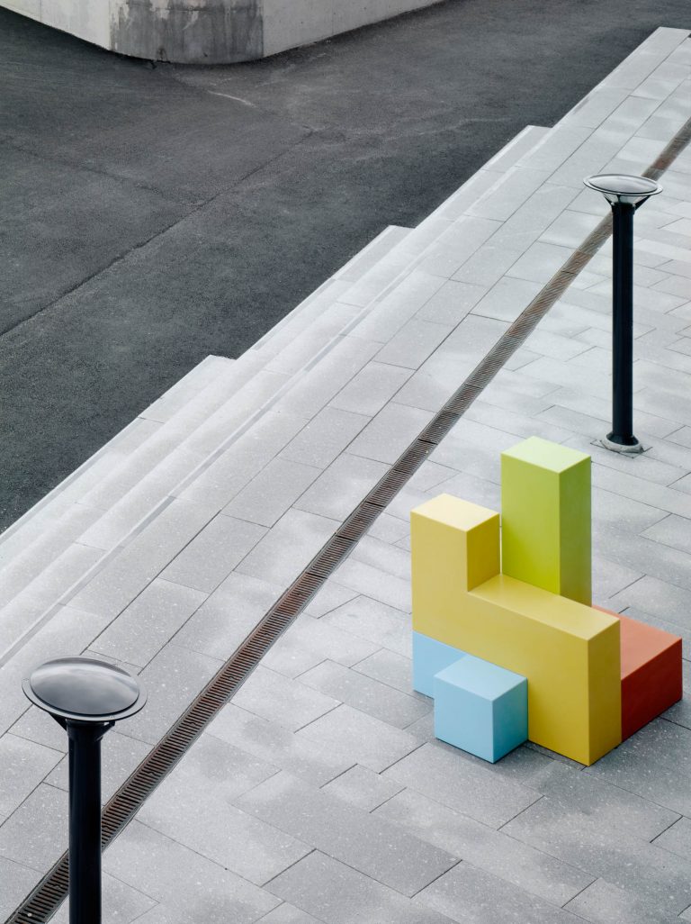 På trottoaren står en grön, gul, orange och blå skulptur. Jacob Dahlgren, Tetris, 2012.