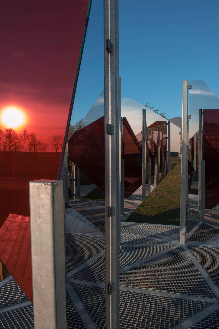 På nära håll skapas en mosaik av speglingar. Även den sjunkande solen fångas av glaset. Patrik Aarnivaara, Tidsglänta, 2013.