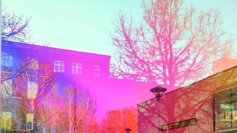 Genom glaset syns rosa och lila reflektioner och speglingar av hus och träd. Torbjörn Johansson, Källan Är