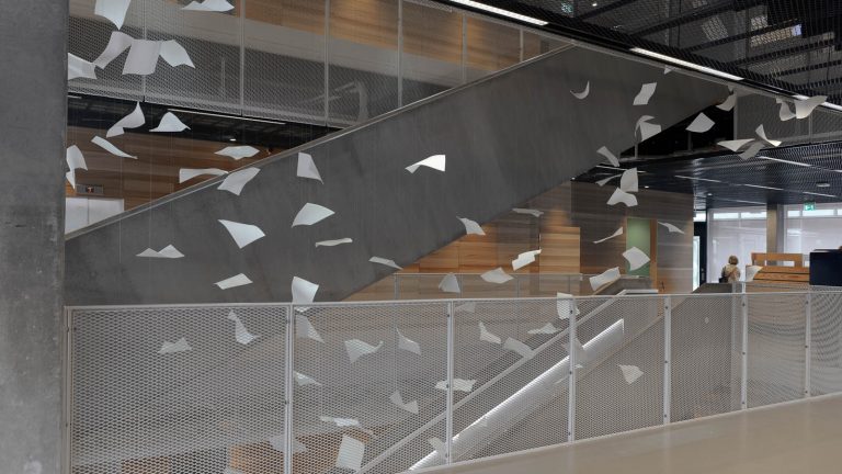 Ett stort antal virvlande pappersark i luften i trappvalvet på Studenthuset. Gabriel Lester, Twirl