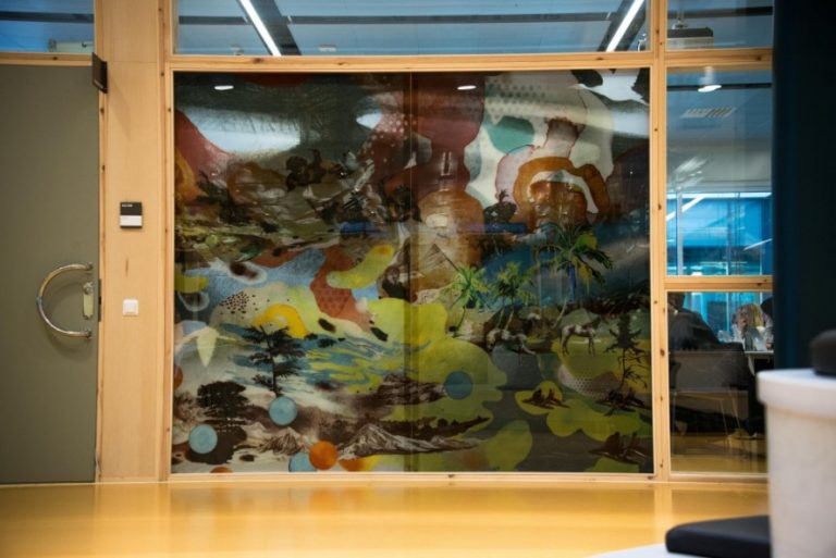 Färgglad målning på glasvägg, på andra sidan väggen skymtar studerande. Christoffer Paues, All Världens Djur