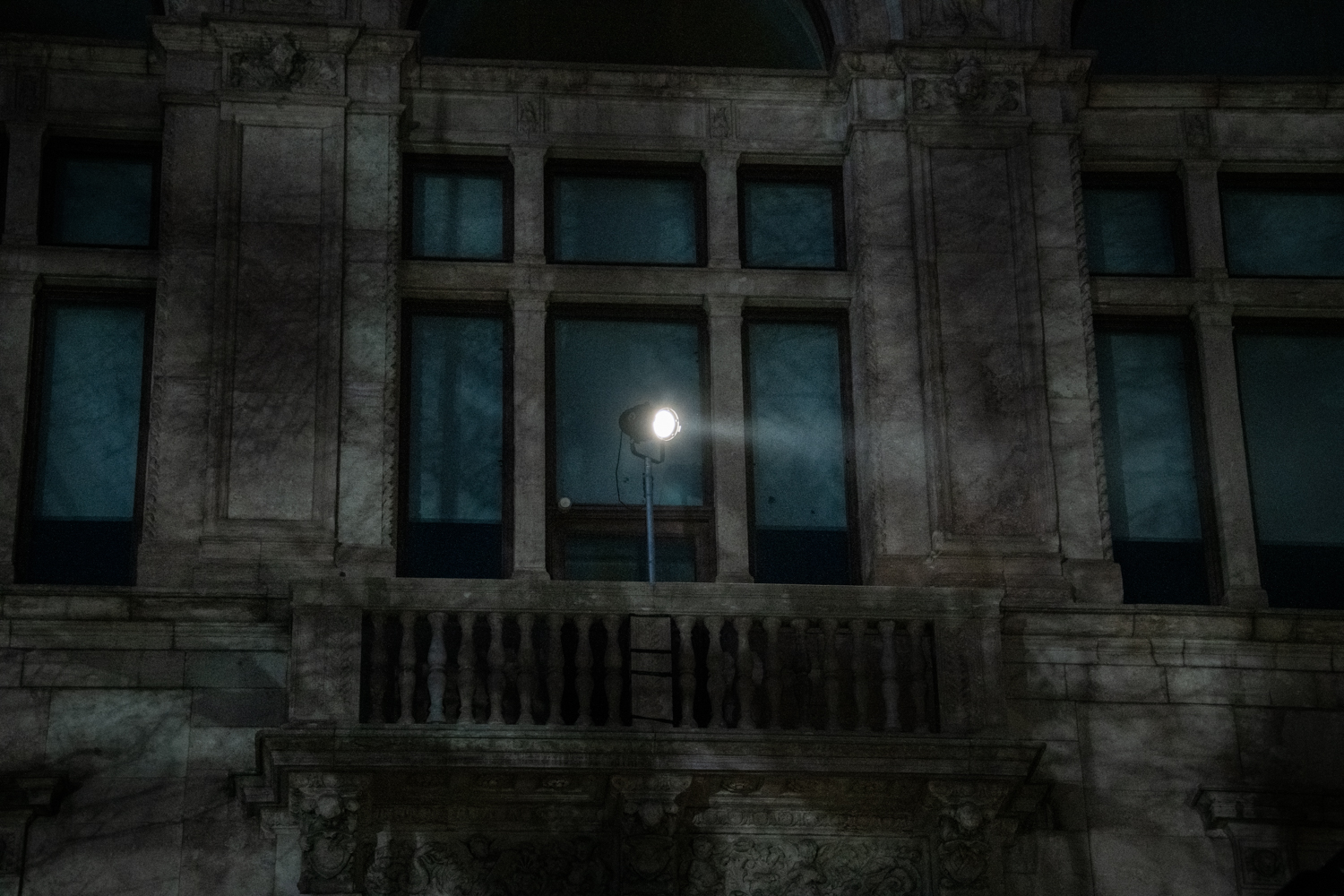 I verket Förhandlingen lyser en lampa på fasaden på Konstakademien i Stockholm.