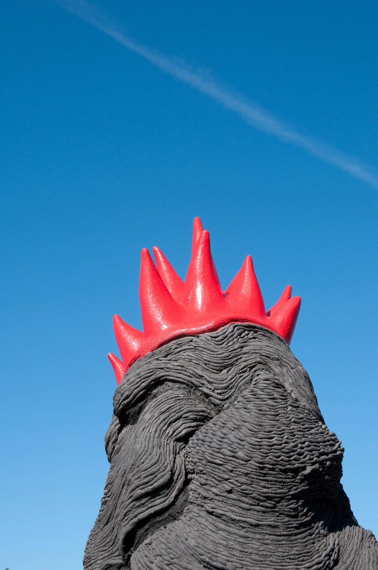 En pösande svart lerfigur med en nedhasad rödglänsande ”krona”. Jennifer Forsberg, En liten berättelse i tre delar