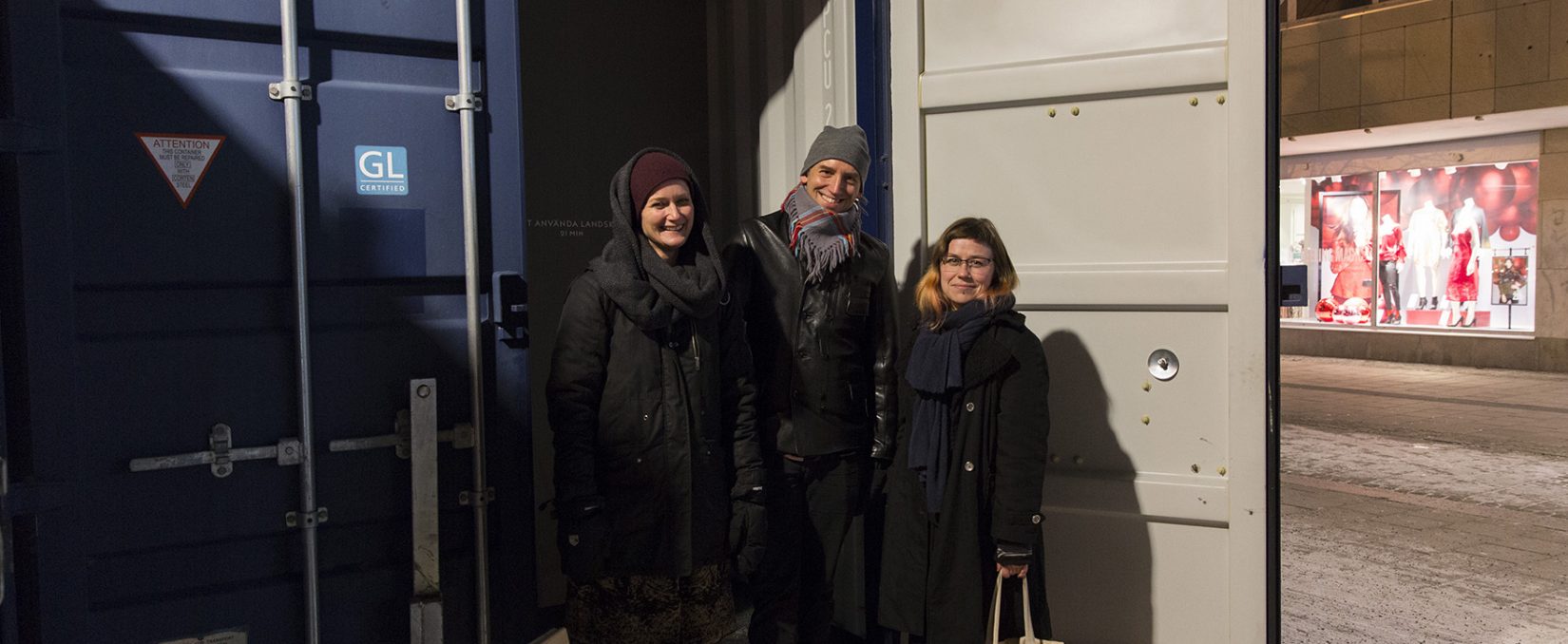 Bild på konstnärerna som står framför en container