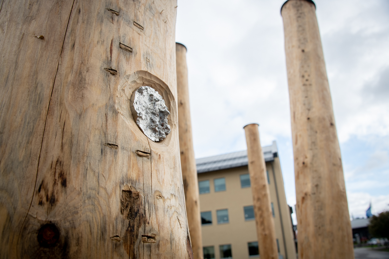 Detaljbild av en trästolpe med snidat mönster och metalldetaljer.