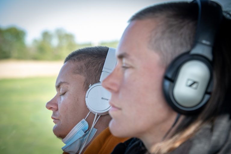 Två personer med hörlurar på en buss