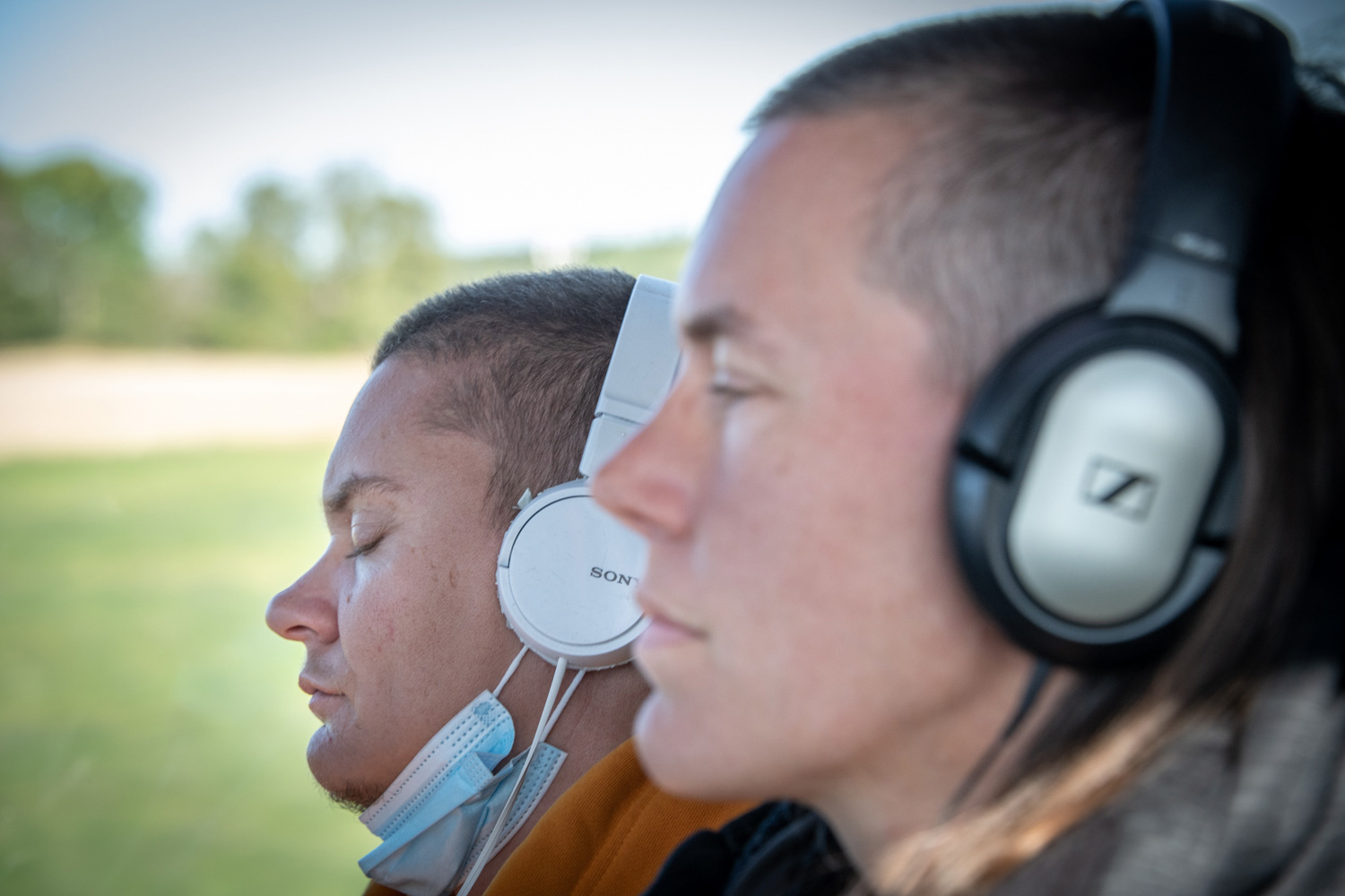 Två personer med hörlurar på en buss