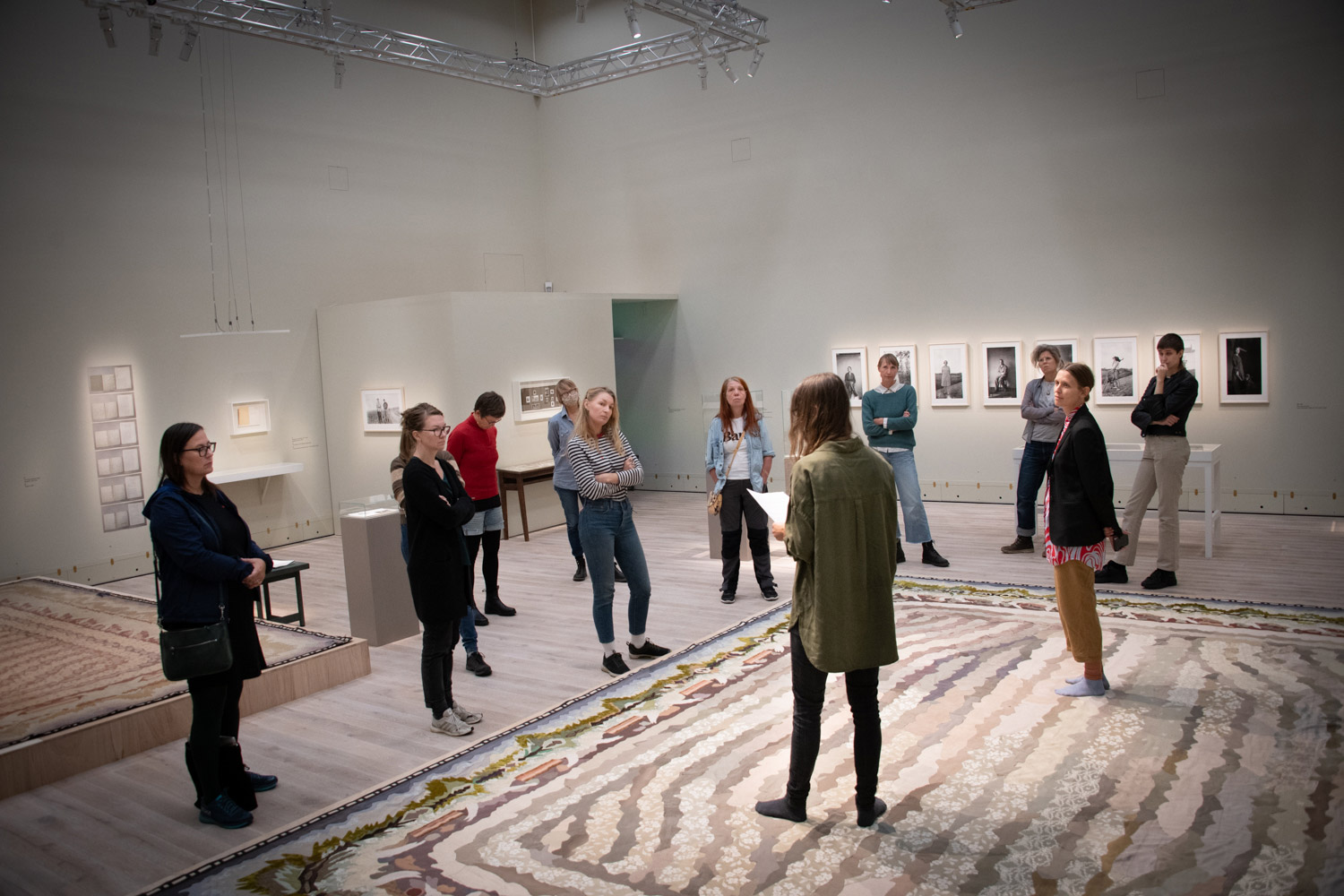 Personer står och lyssnar på en person som pratar