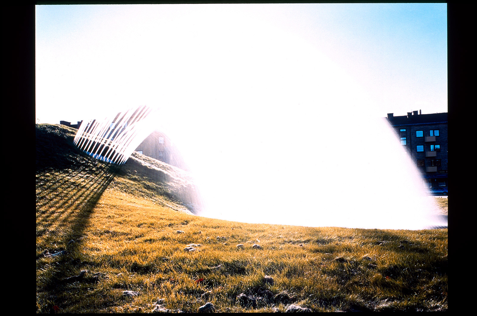 Fontän som sprutar vatten över en gräsmatta