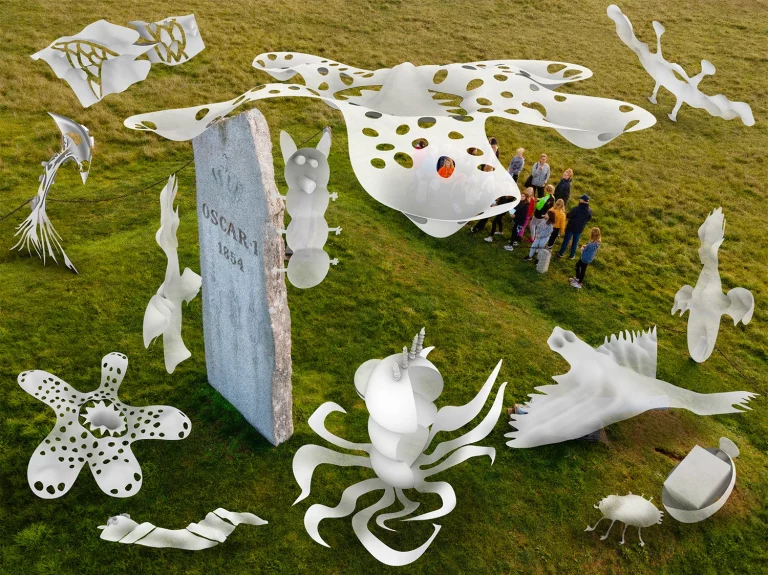 En grupp elever står på en gräsmatta och tittar på en gravsten som sticker upp och över dem flyger animerade monster.