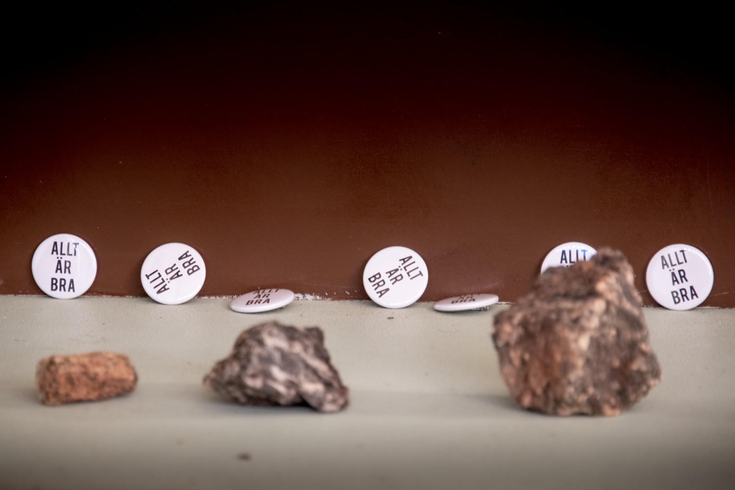 Bild på ut placerade stenar och pins. På pinsen står det Allt är bra.