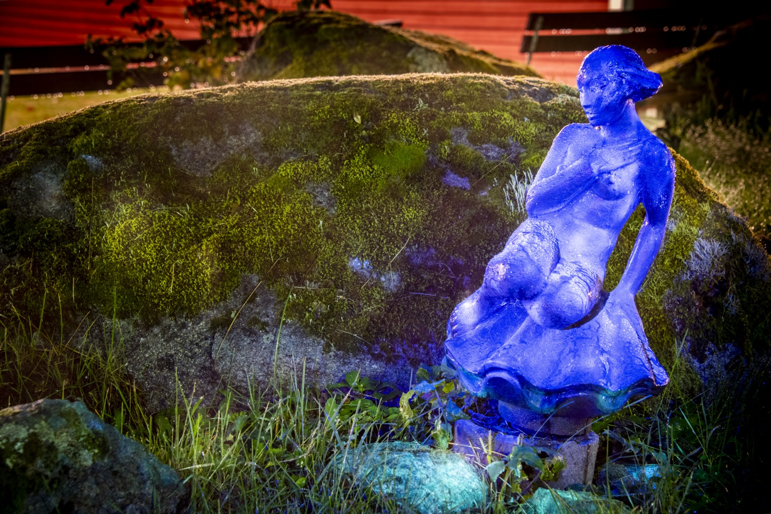 Ett fluorescerande verk. En kvinna som sitter på en snäcka.