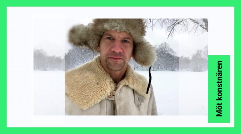 Portätt bild på konstnären Erik Alto. Konstnären står i ett vinterlandskap och tittar in i kameran. Han har en stor varm mössa på sig.