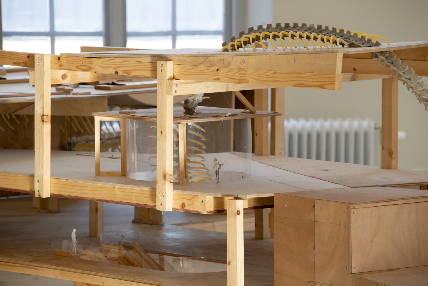 Trämodell. Man ser små människor och skellet av en orm.