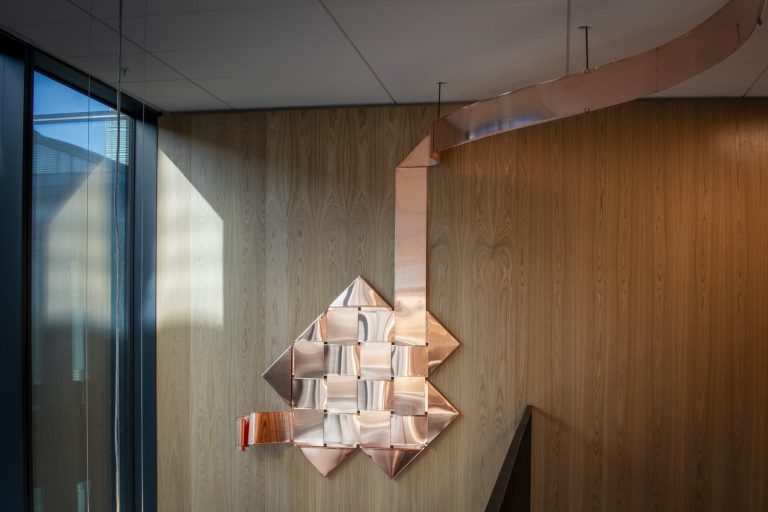 En väggmonterad spegel på en trävägg