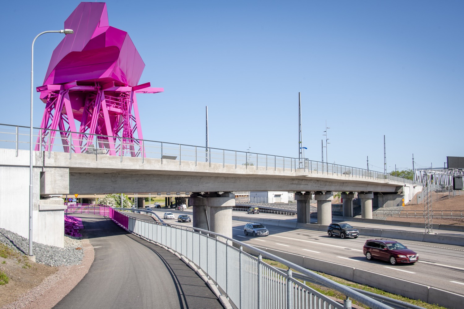En rosa skulptur vid sidan av en motorväg.