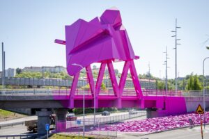 En rosa skulptur vid sidan av en motorväg.
