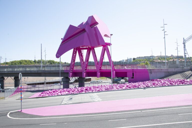 En rosa skulptur vid sidan av en motorväg.