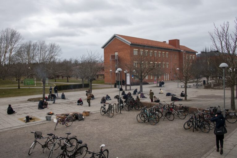 Stadsbild och människor som sitter på marken