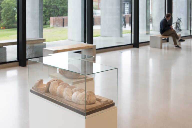 En person som sitter på en bänk i ett rum