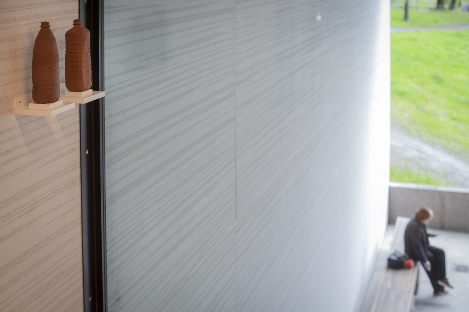 En person som sitter på en bänk i ett rum