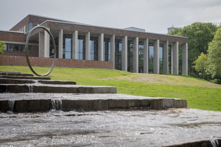 En byggnad med en fontän framför