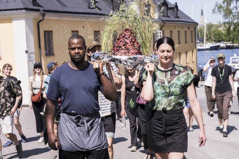 En grupp människor som går längs en gata.