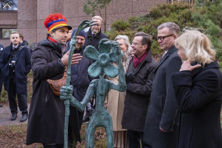 En grupp människor som står runt en staty.