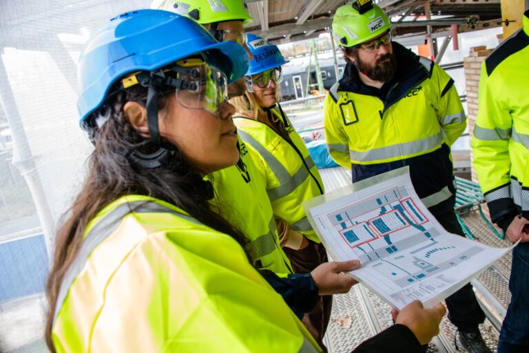 Flera personer i ring i en byggnadsarbetsplats