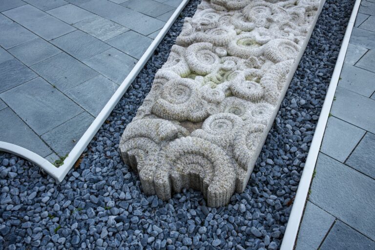 Vit skulptur som står på en stenplatta.