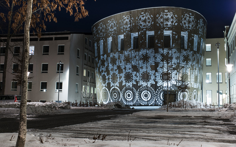 Bild på verket Blomman från Weena en fasad. Ljuset lyser igenom fasaden.