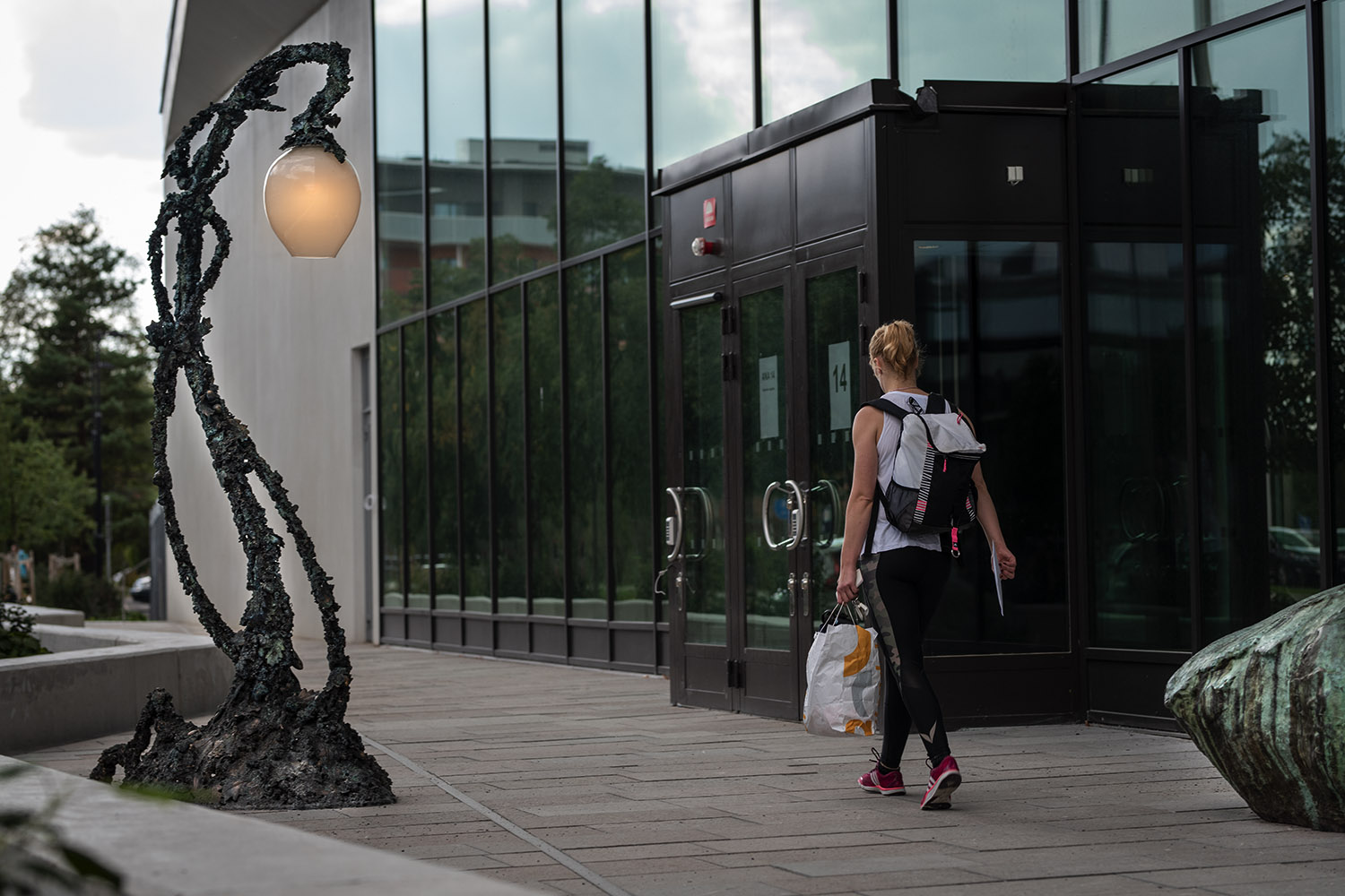 Verket Sten och Lykta samt rödhårig kvinna med kasse