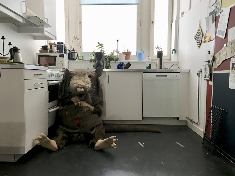 Scen ur pjäsen Vilka är ni med en råtta som sitter på golvet