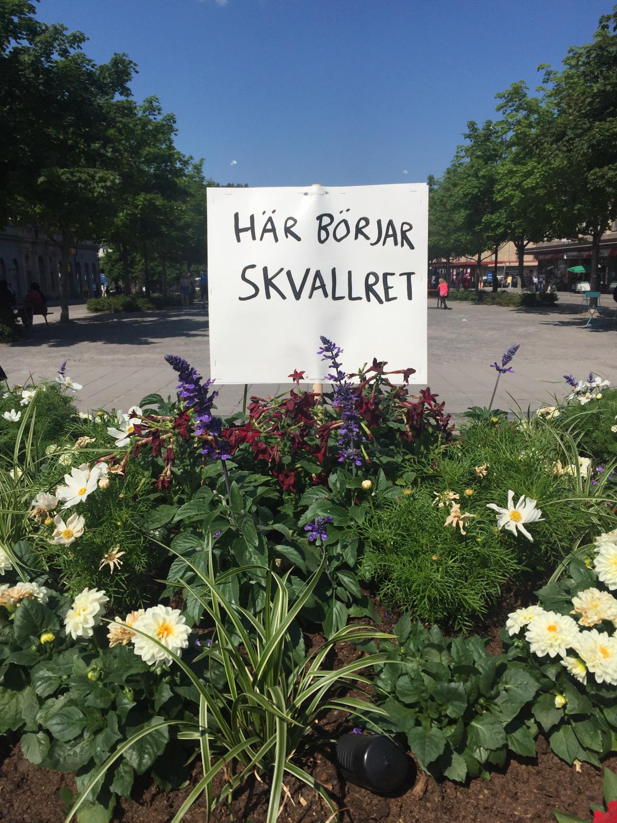 En skylt med texten Här börjar SKVALLRET i en rabatt.