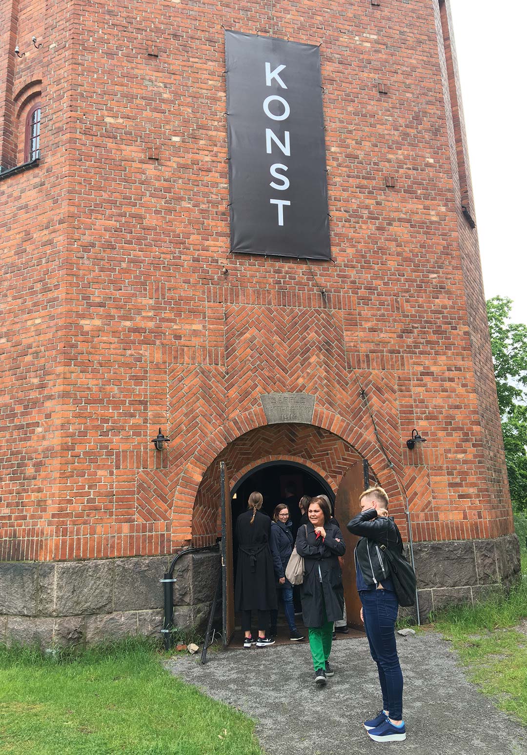 Personer vid tegelbyggnad