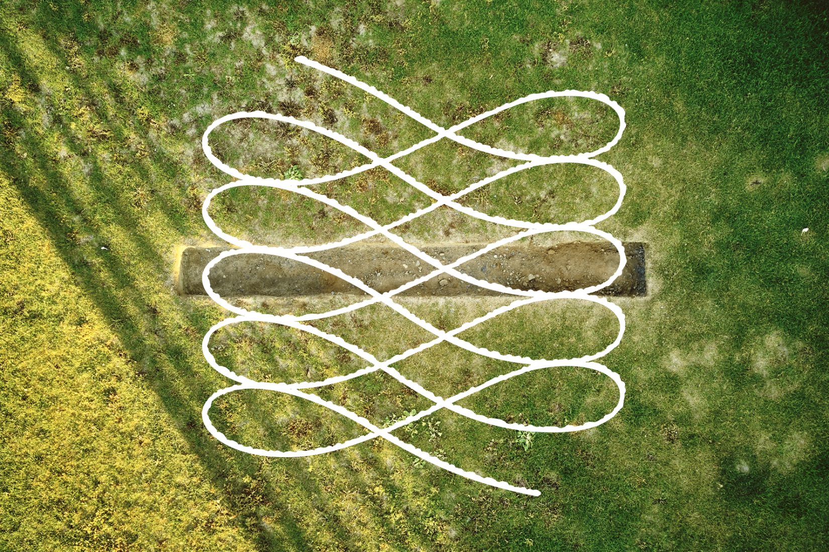 En gräsmatta som en långsmal grop har grävts i.