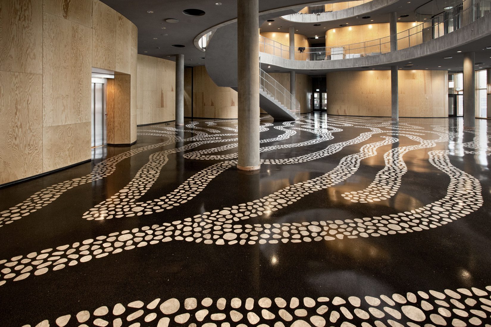 Mörkt golv med mönster i hus med flera våningar och pelare-