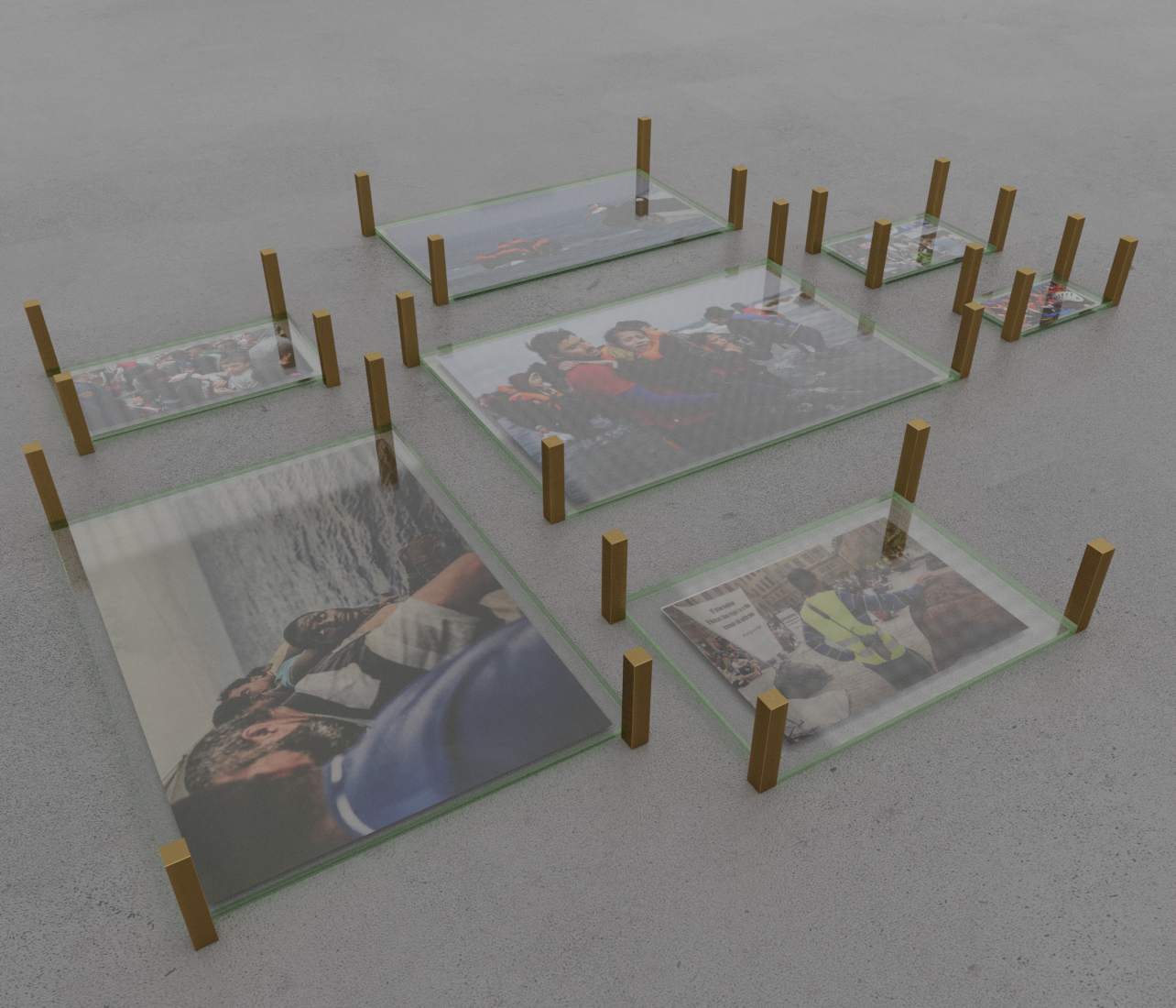 Inglasade bilder ligger på ett golv. Fyrkantiga bronsstavar markerar kanterna på bilderna.