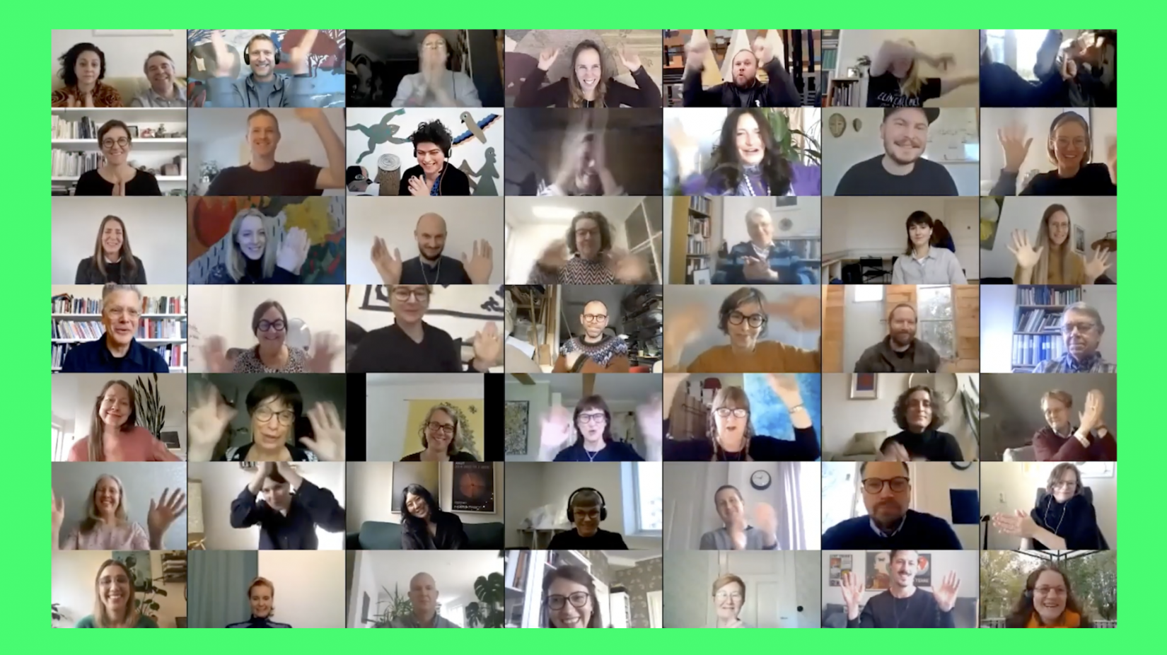 Man ser en stor mängs personer på en webbsändning som vinkar mot datorns kamera.