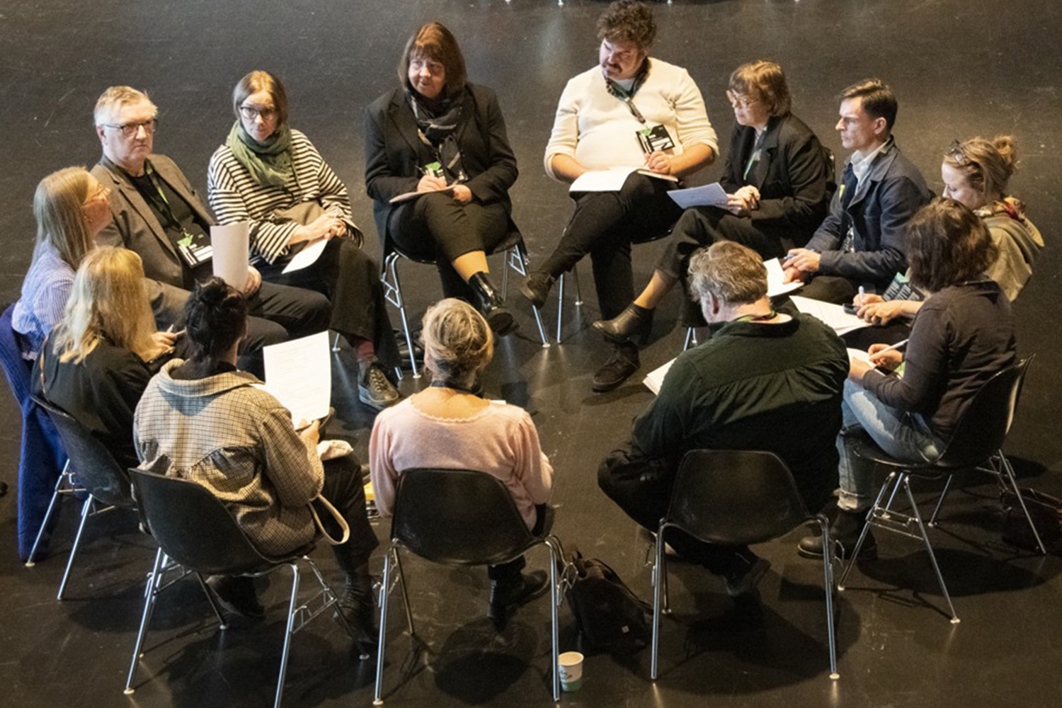 En grupp människor sitter i en ring och pratar