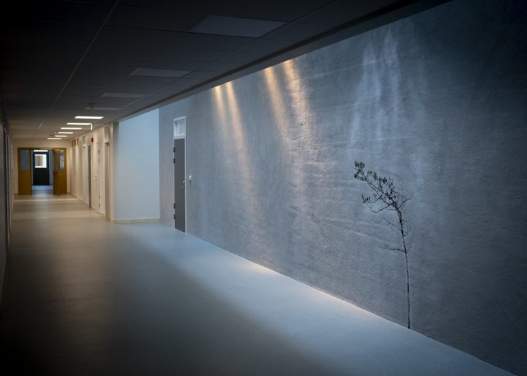 Liten tall belyst på en vit väggyta