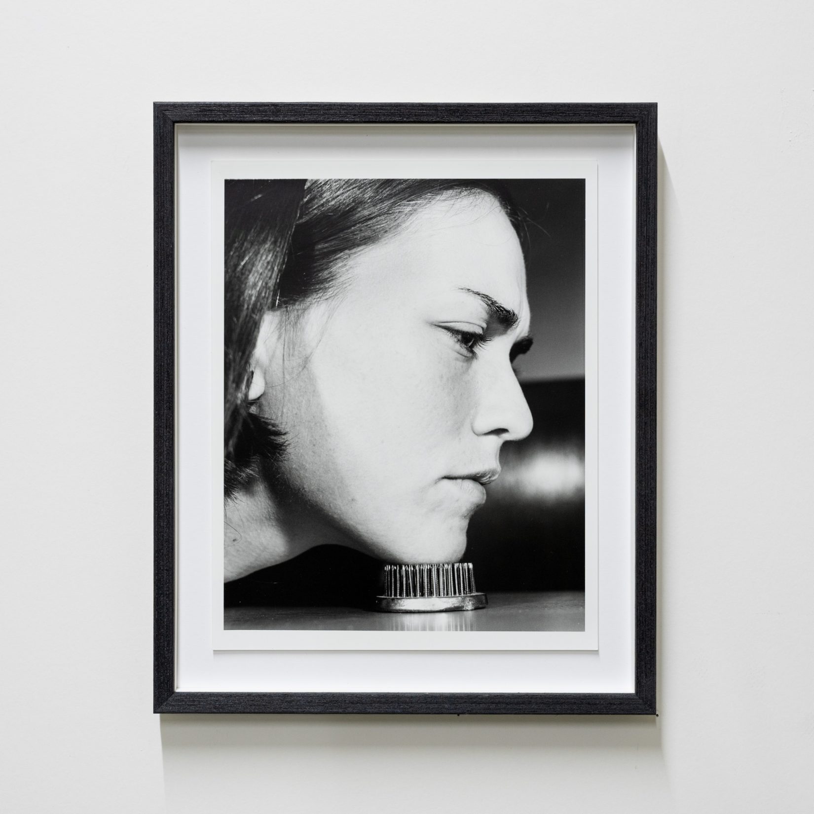 kvinna lutar hakan mot spikmatteliknande föremål