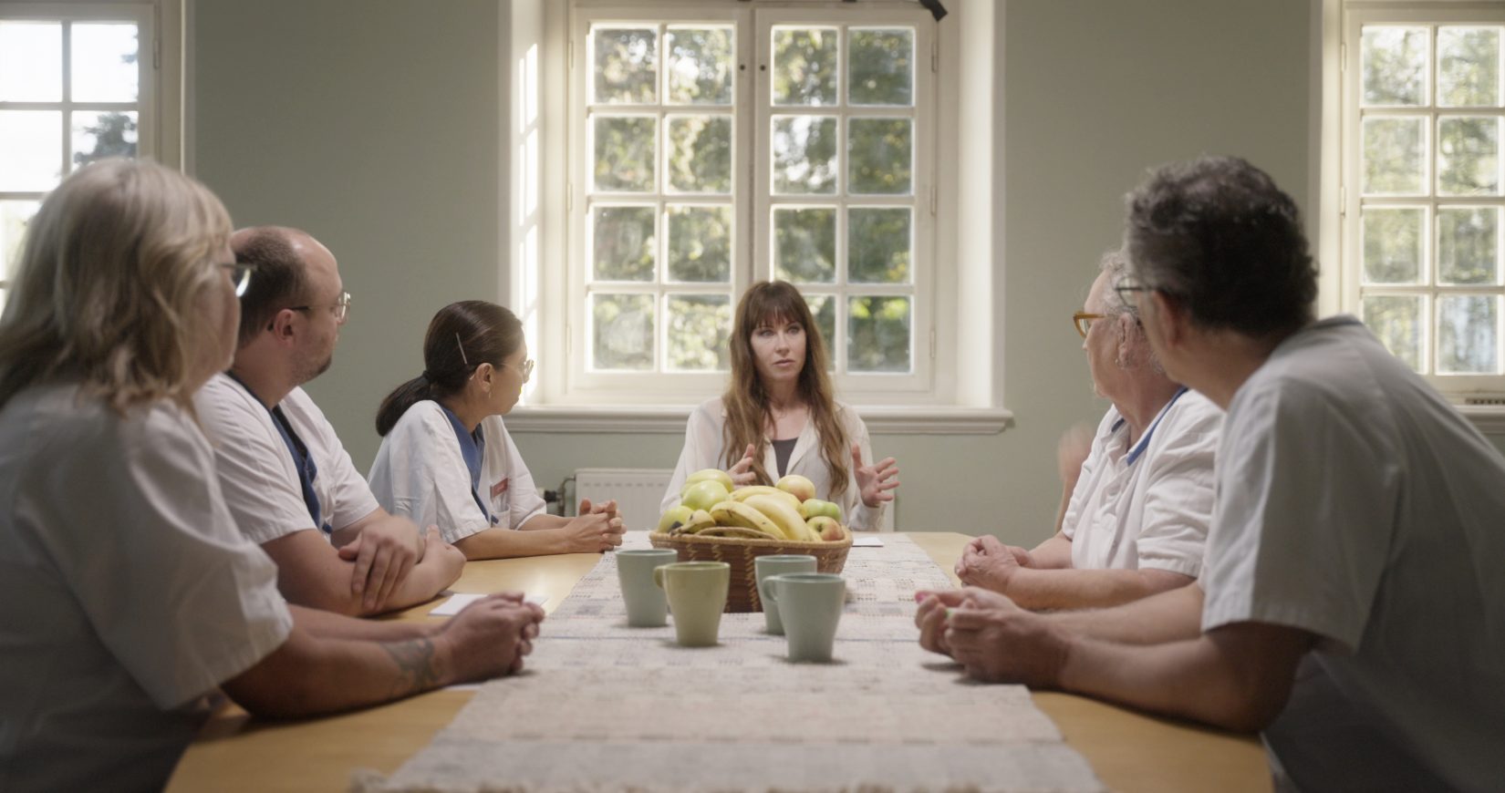 kvinnor sitter runt ett stort bord och pratar