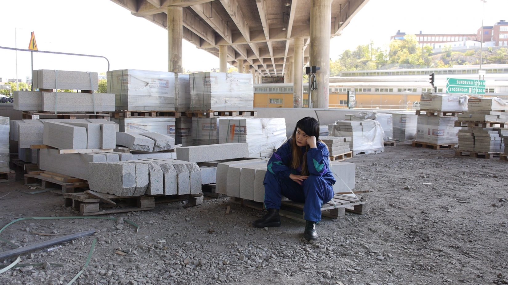 En kvinna sitter och tänker på betongblock
