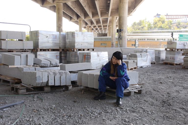En kvinna sitter och tänker på betongblock
