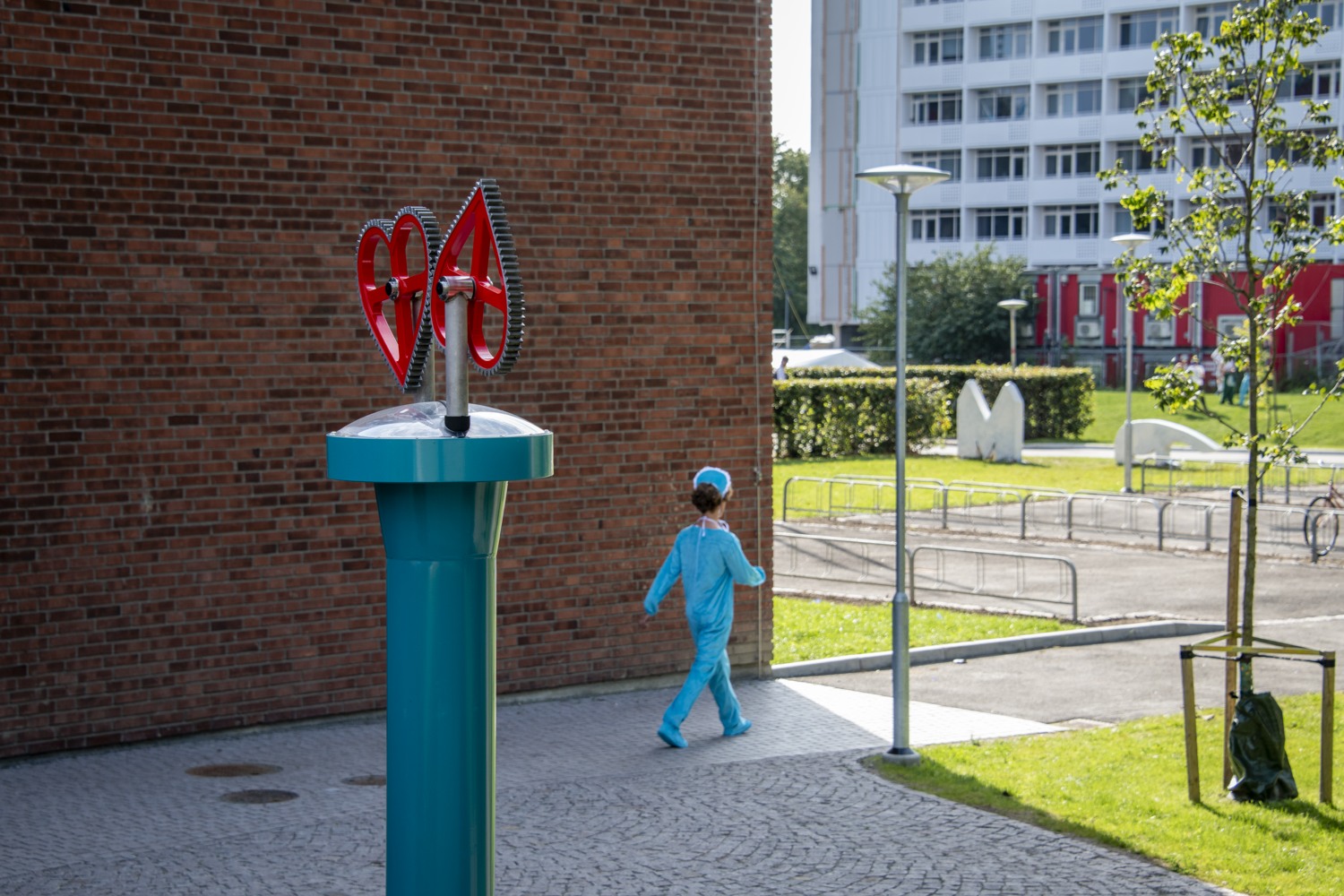 En liten pojke som går förbi en skulptur