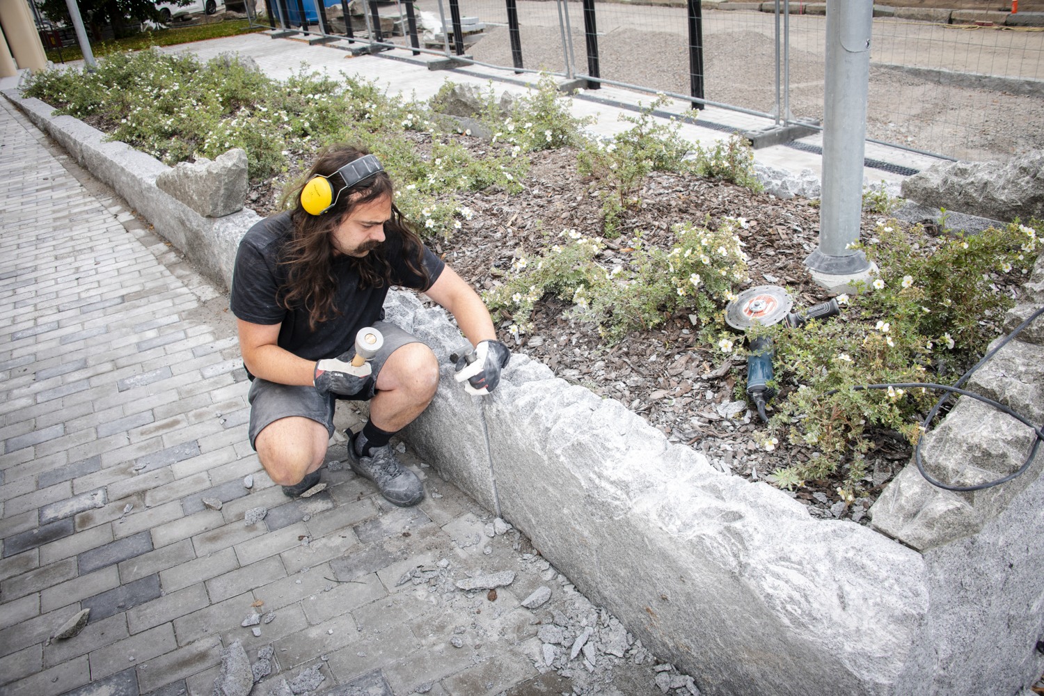 En man sitter på marken med en skateboard