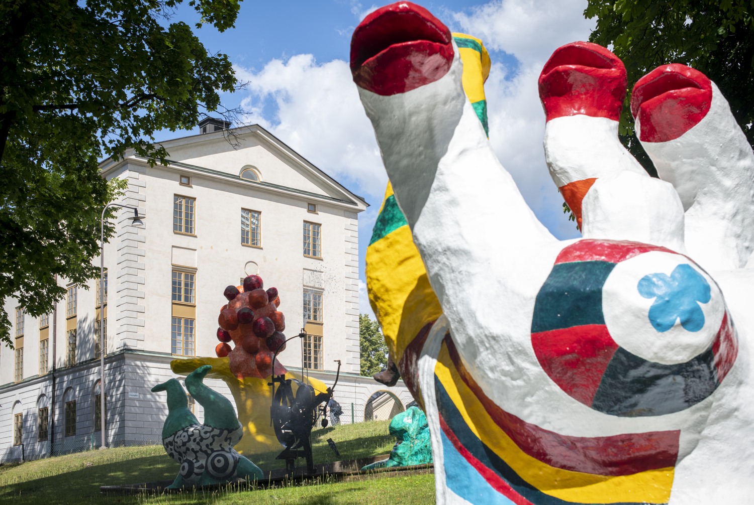En stor färgglad staty framför en byggnad.