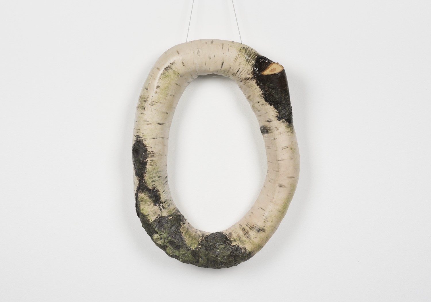 Ett vitt och svart föremål som hänger på en vit vägg.